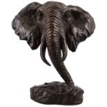 A modern lost wax bronze sculpture depicting the head of an elephant, raised on naturalistic base,