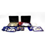 Two leather Masonic cases lined in blue velvet, containing ceremonial aprons, gloves, sashes and
