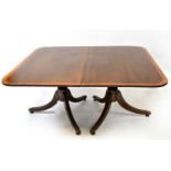 A 19th century crossbanded mahogany extending dining table on three pedestal legs, with three