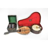 CRANE & SONS; a cased banjo, an early 20th century squeeze box, and a balalaika (af) (3).