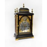 An ebonised gilt metal mounted eight-day mantel clock with pagoda case above arched dial set with