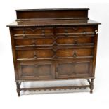 A Jacobean-style oak chest of two short over three long drawers, on turned feet united by