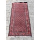 A Kayam red ground rug, 204 x 103cm.