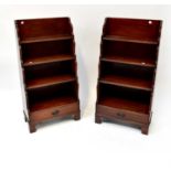 A pair of reproduction mahogany four-tier waterfall bookcases, each with single drawer, on bracket