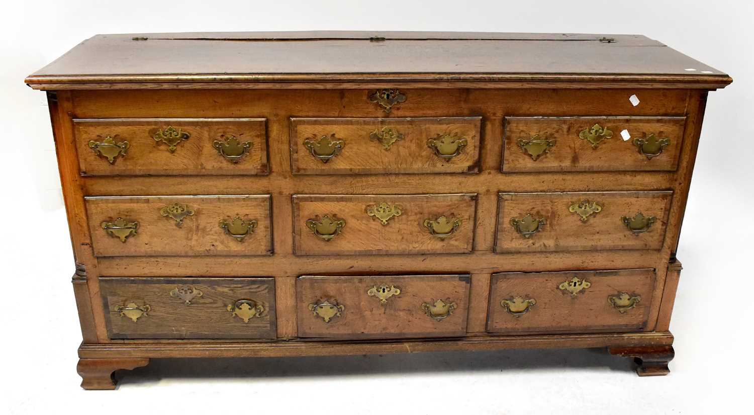 A Georgian oak mule chest with lift-up top and six faux drawers above three short drawers, on ogee