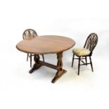 A mid-20th century oak priory-style draw-leaf dining table with shaped slab ends, cross stretcher