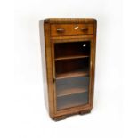 A 1930s walnut display cabinet with single drawer, on stylised bracket feet, 128 x 64 x 33cm.