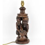 An early 20th century carved wood table lamp with two African figures to the middle, height 39cm.