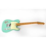 FARIDA; an electric guitar with turquoise body and white emblem.