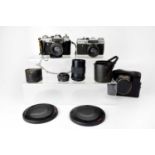 A small quantity of vintage cameras comprising a Zenit-E, a Zenit EM, a Cosinon Auto F=2.8 lens