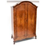A modern mahogany dome-topped double wardrobe with shelf and rail to the interior, on four short paw