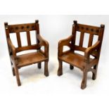 A pair of ecclesiastical oak thrones with caved details to the top rail, solid seats and sabre front
