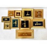 Nine highly polished brass taps mounted on velvet upholstered cushion plinths in gilt frames,