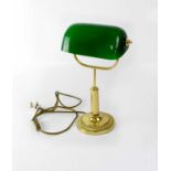 A reproduction brass-effect library lamp with adjustable green glass shade.