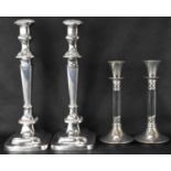 A pair of early 20th century silver plated candlesticks with square urn top, on tapered columns to