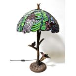 A Tiffany style leaded stained-glass lamp, the shade decorated with wisteria and butterflies on a
