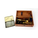 A. FRANKS OPTICIAN, MANCHESTER; A cased brass monocular microscope with additional tin of unused