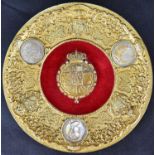 A Spanish King Alfonso XIII gilt metal circular plaque, centre shield under coronet within a