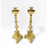 A pair of 19th century brass ecclesiastical candlesticks with wrythen knopped stems on triangular