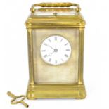 A late 19th century brass chiming carriage clock with glazed panels top front and sides, the white