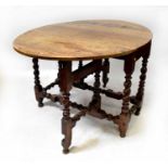 An early 19th century gateleg oval table with peg joints, twist supports and short bun feet, 76 x