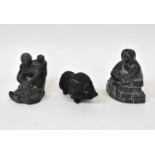 A group of three Inuit sculptures comprising a mother, child and dog by Wolf Sculptures, a figure