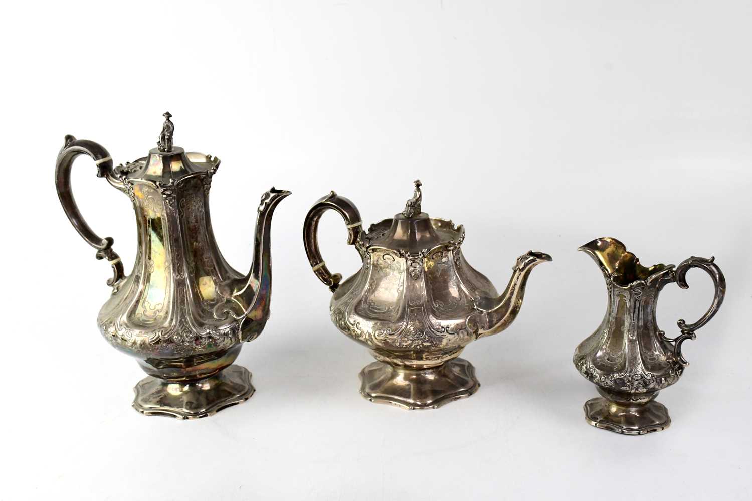 A Victorian silver part tea service of baluster form with repoussé decorated panels and scroll