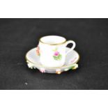 MEISSEN; a late 19th early/20th century cabinet cup and saucer, decorated with embossed painted