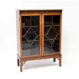 A mid-20th century mahogany bookcase with blind fret frieze to the top, astragal glazed doors with