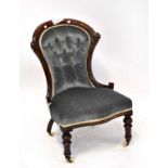 A Victorian carved walnut nursing chair, with button back upholstery, in blue velour and on turned