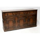 An oak reproduction sideboard, three single drawers with turned wood knobs over three-door cabinet