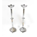A pair of chromed metal ecclesiastical candlesticks with knopped stems, on domed bases with claw
