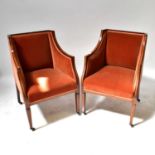 A pair of Edwardian mahogany inlaid tub chairs with outswept arms to four tapering supports and