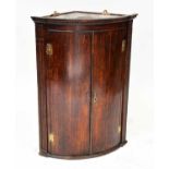 A George III oak bow-fronted hanging corner cupboard with fluted uprights.Condition Report: Damage