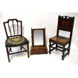 An 18th century jointed hall chair with carved top rail, pyramid finials, hard seat and turned front