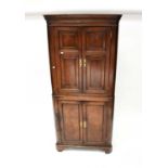 A late George III oak freestanding corner cupboard with dentil moulded cornice, above panelled