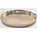 A large oval silver plate tray with tall wavy galleried edge and pierced band, cut-out handles and