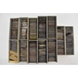 Twelve coin boxes, each containing individual coin wallets with various, mostly pre-decimal and