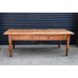 A 19th century chestnut plank top table with cleated ends and three frieze drawers, raised on ring
