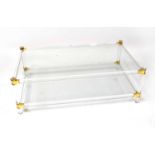 ATTRIBUTED TO PIERRE VANDEL; a Lucite two-tier coffee table with glass shelves and gold-coloured