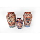 A pair of Japanese Meiji period baluster vases with floral decoration and vignettes of prunus
