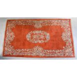 A terracotta ground floral rug, length 121cm.