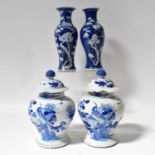 A pair of late 19th century Chinese blue and white baluster vases and covers, both with painted