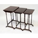 An Edwardian rosewood nest of three tables with thin turned supports, on arched feet, the largest 69