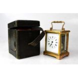 A c.1900 leather cased brass carriage clock, the white enamelled dial set with Roman numerals and