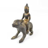 A 19th century Chinese bronze monkey and rider figure, gilt-heightened detail to the headdress,