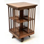 An early 20th century oak revolving bookcase of two tiers, on a quadruped base with castors, 89 x 53