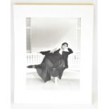 KARL LAGERFELD; a large photograph print of a model reclining on a white bench, signed verso, 40 x