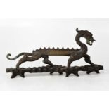 A bronze model of a standing dragon, on a wooden base, height of dragon 13cm, length 33cm.