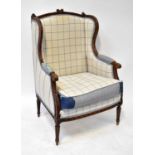 A 19th century French walnut wing armchair with carved frame, to fluted tapering legs, upholstered